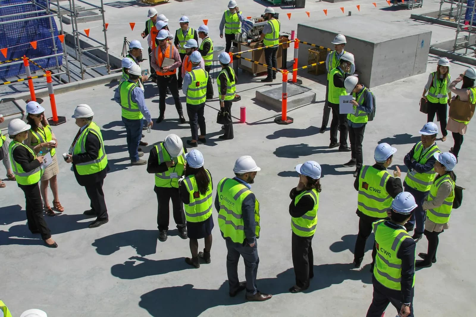 People wearing hard hats and high-visibility vests at a Melbourne construction site.