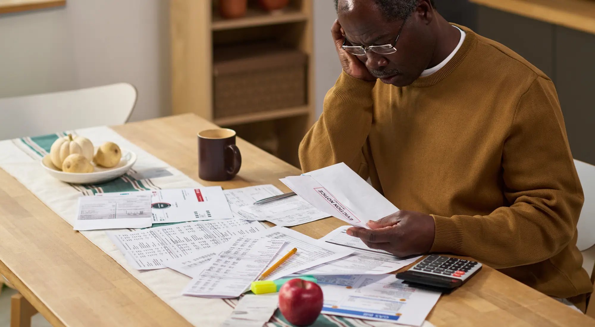 A man reviewing tax bills and paperwork at his dining table