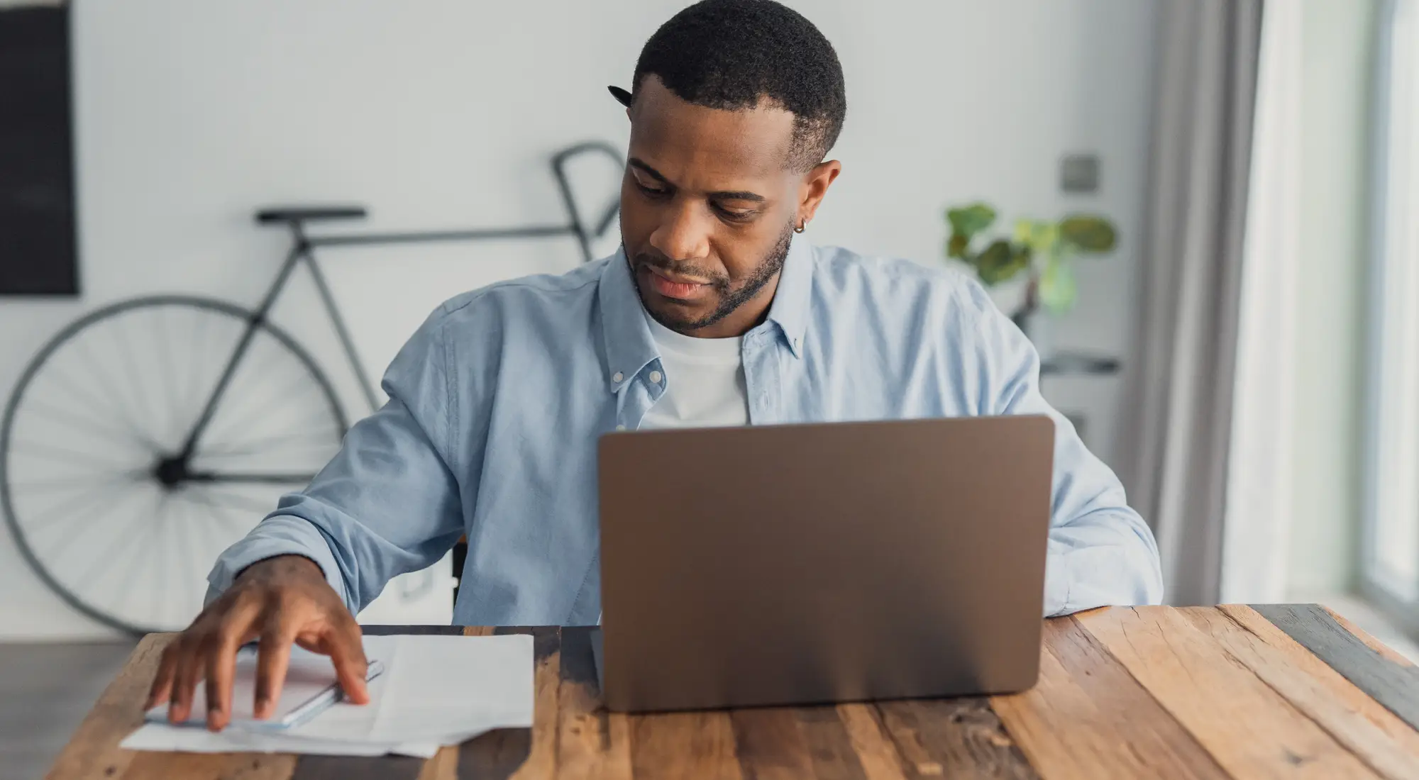 A man reviewing his finances on a laptop at home