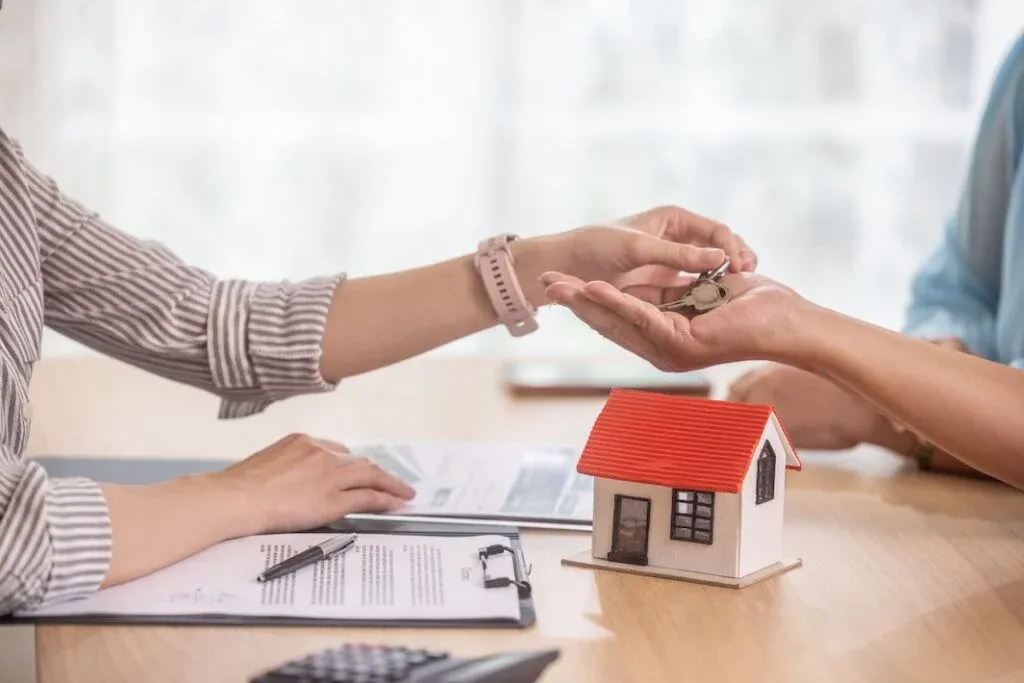 House keys beside a property model