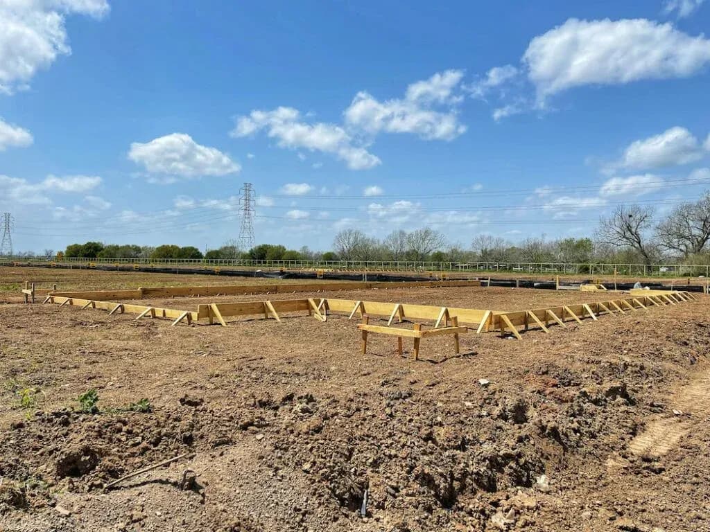 A cleared building site with foundation formwork marked out