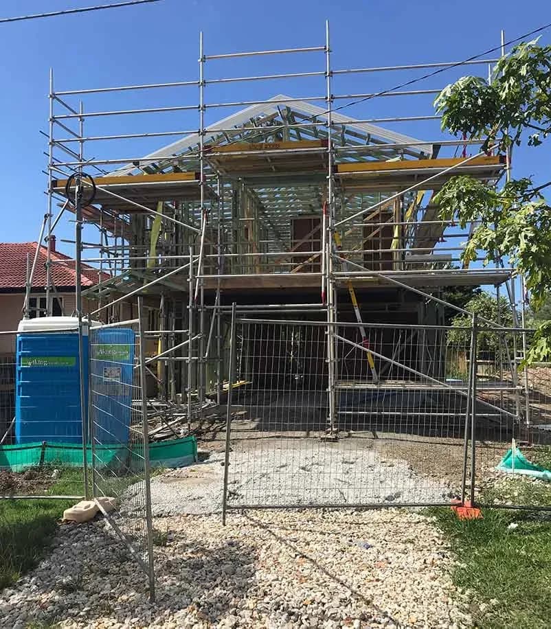 A timber-framed house with scaffolding during construction