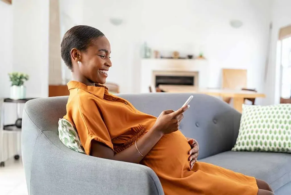 Pregnant home buyer speaking on the phone while planning a home loan application