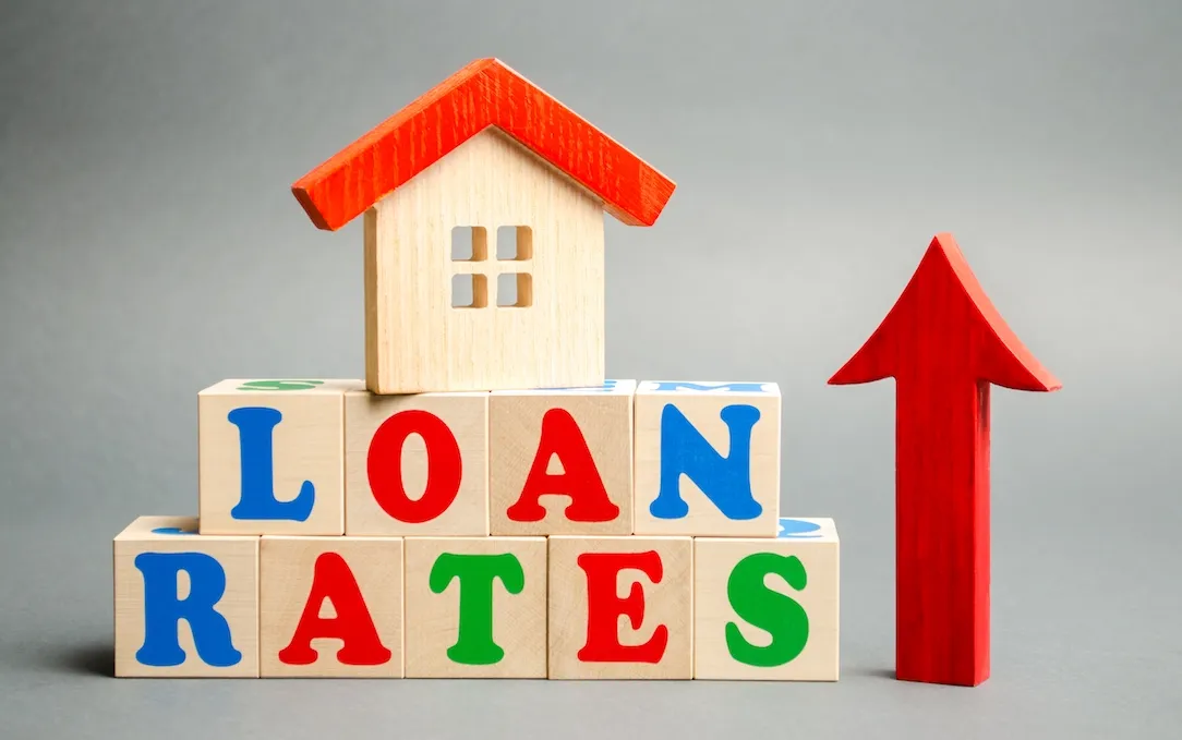 A model house beside blocks spelling loan rates