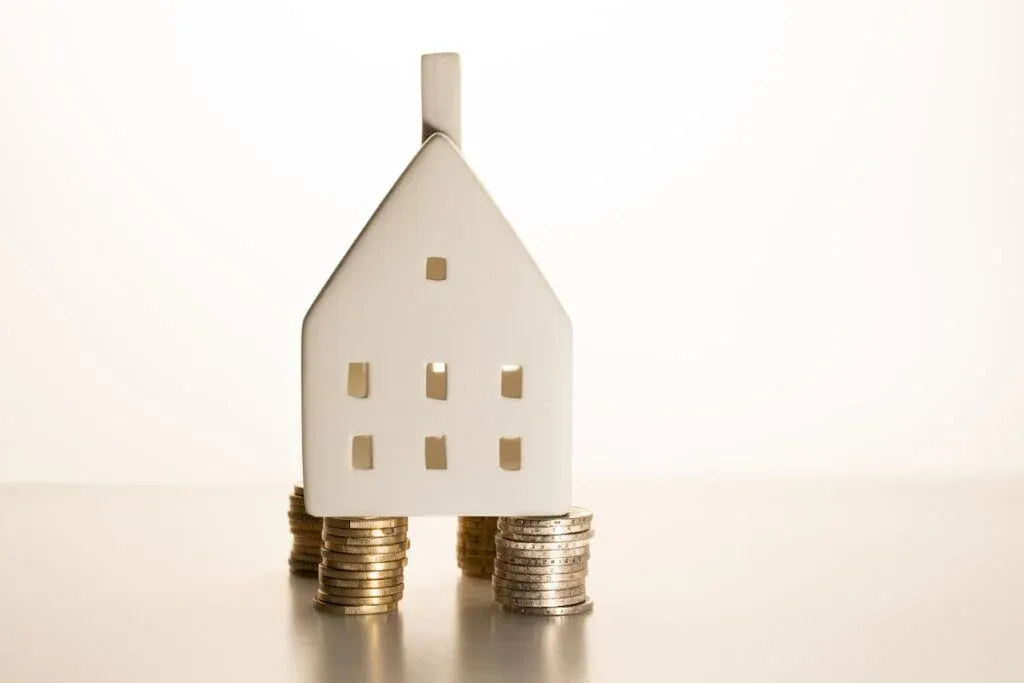A model house resting on stacks of coins