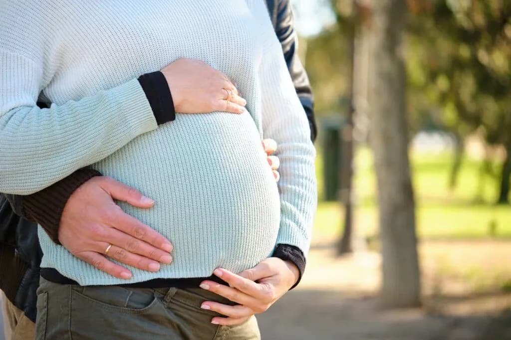 Expectant parents holding a pregnant belly