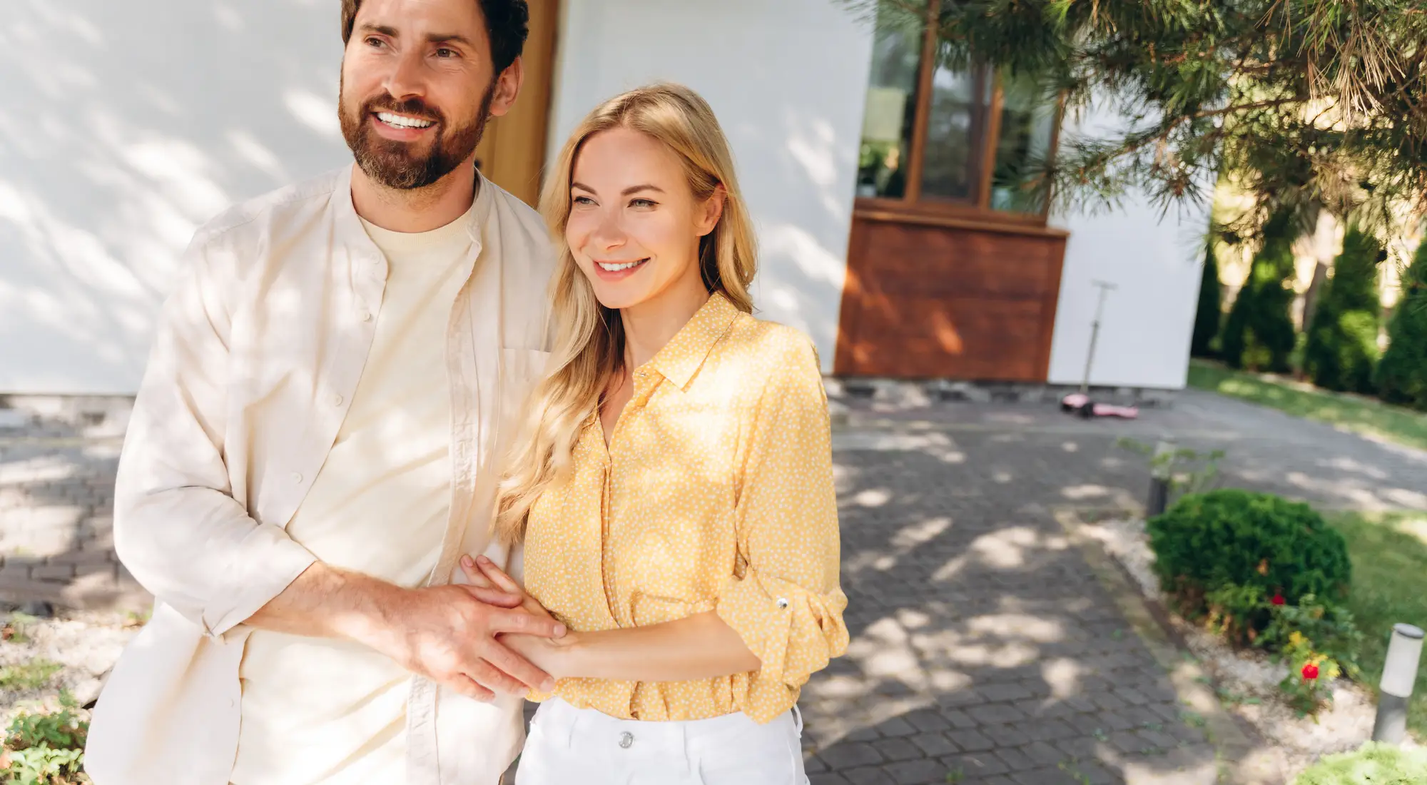 A happy couple standing in front of their home