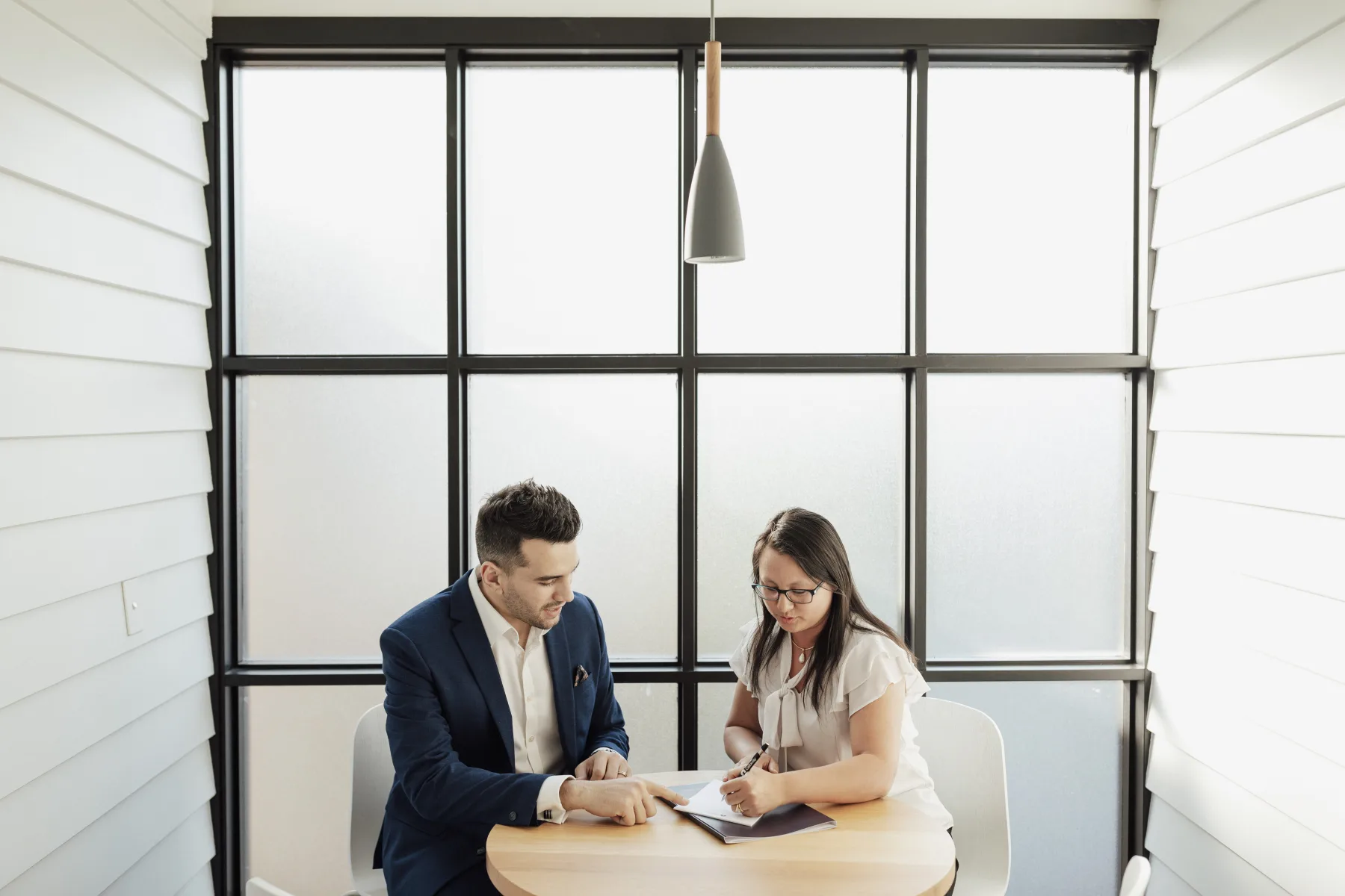 A Hunter Galloway broker working through an application with a client at the Brisbane office